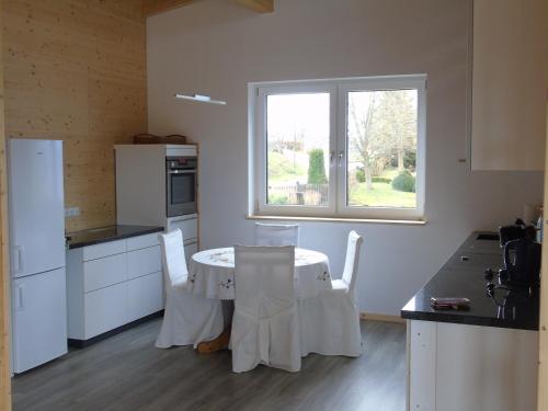a kitchen with a table with chairs and a window at Penthouse Mosel Hunter in Gornhausen