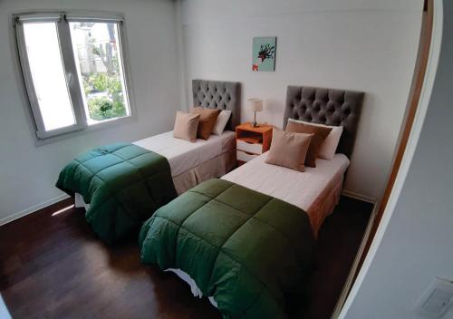 een slaapkamer met 2 bedden en een raam bij Departamento en el centro de Bariloche ca in Bariloche