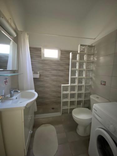 a bathroom with a white toilet and a sink at Mpanos Sea Apartment 1 in Loutra Oraias Elenis