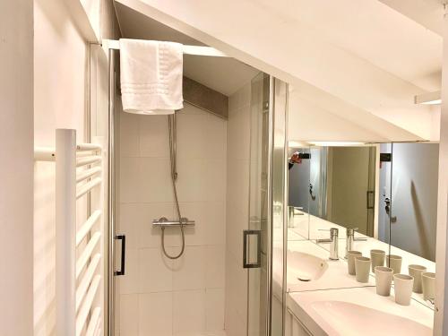 a bathroom with a shower and two sinks and a mirror at Residence Service Appart Hôtel in Clamart