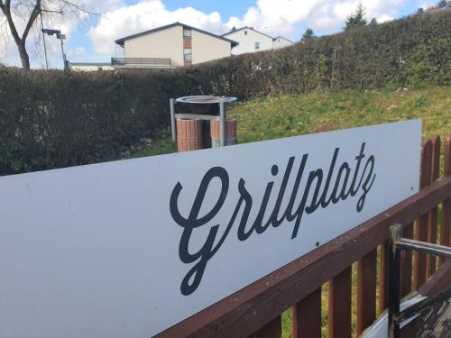 a sign on a fence with a house in the background at Pension Reinhardshäusle in Reinhardshausen