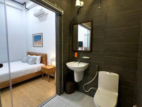 a bathroom with a sink and a bed and a mirror at Daisy House in Tuy Hoa