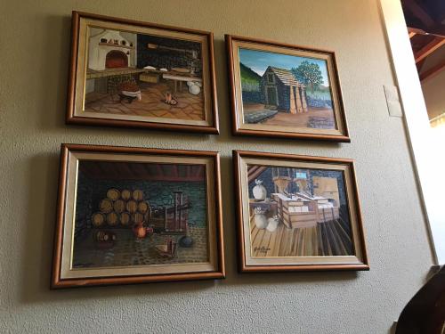 a group of four pictures hanging on a wall at Palheirinho da Camélia in São Vicente