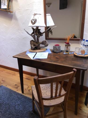 a desk with a lamp on top of it with a chair at La Chambre des Rêves in Aosta