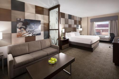 a hotel room with a bed and a couch at Holiday Inn Express & Suites Oklahoma City Downtown - Bricktown by IHG in Oklahoma City