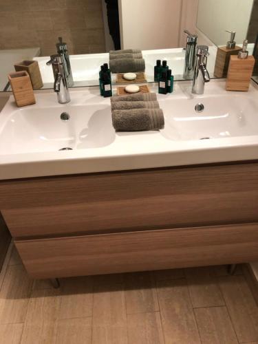 une salle de bain avec un lavabo blanc et un miroir dans l'établissement Grande Marina Vue Port, à Deauville