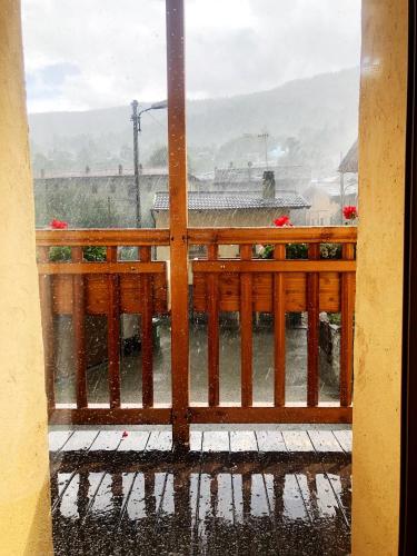 a view of a balcony in the rain through a window at La Chambre des Rêves in Aosta