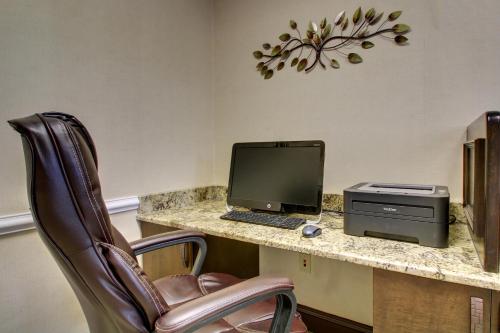 a computer sitting on a desk with a chair at Holiday Inn Express Hotel & Suites Live Oak by IHG in Live Oak