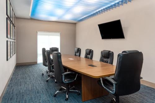 a conference room with a wooden table and black chairs at Holiday Inn Express & Suites St. Louis - Chesterfield by IHG in Chesterfield