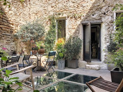 a patio with a table and chairs and plants at La vie de chateau in Grignan
