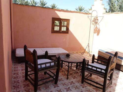 a patio with two chairs and a table and a table and chairs at Dar Nakhla - Zagora guest house in Zagora