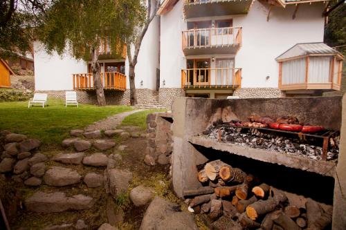 a stone path leading to a building with a grill at Cabañas Rucaleufu in San Martín de los Andes