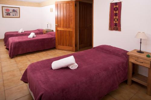 two beds in a hotel room with towels on them at Cabañas Rucaleufu in San Martín de los Andes