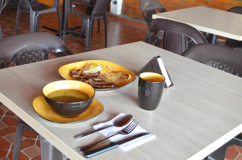 a table with a plate of food and a cup of coffee at Hotel Balcon Llanero in Cúcuta