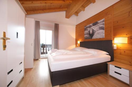 a bedroom with a bed and a wooden wall at Edelweiss am See in Zell am See