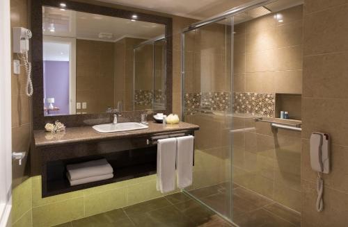 a bathroom with a sink, toilet, and shower stall at Mercure Alameda Quito in Quito