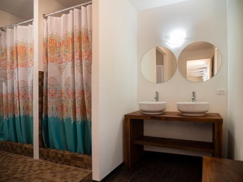 a bathroom with two sinks and a mirror at Colorbox beds and rooms in Tulum