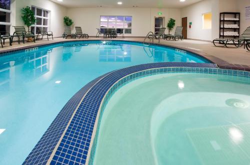 a swimming pool with a pool table and chairs at Holiday Inn Express Hotel and Suites Stevens Point, an IHG Hotel in Stevens Point
