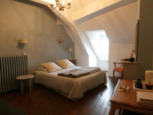 um quarto com uma cama e um sótão em La Maison XVIIIe em Moulins