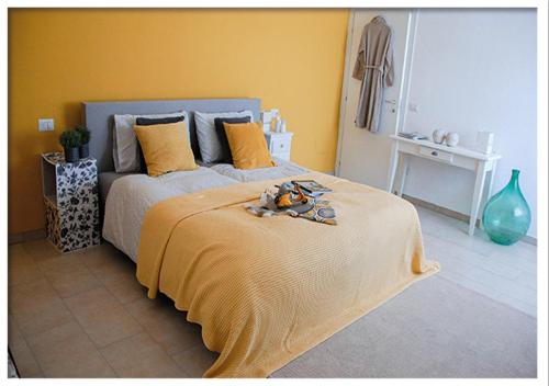 a bedroom with a bed with a yellow wall at Casa Valtaro in Borgo Val di Taro