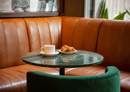 a coffee table with a cup of coffee and pastry on it at Sixties Ramblas in Barcelona