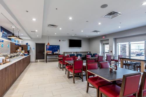a restaurant with tables and chairs and a bar at Holiday Inn Express & Suites Jersey City North - Hoboken by IHG in Jersey City