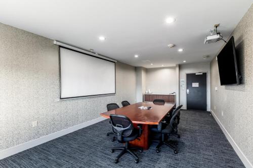 a conference room with a table and chairs and a screen at Holiday Inn Express & Suites Jersey City North - Hoboken by IHG in Jersey City