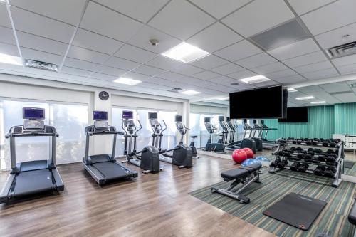 a gym with tread machines and a flat screen tv at Holiday Inn Express & Suites Jersey City North - Hoboken by IHG in Jersey City