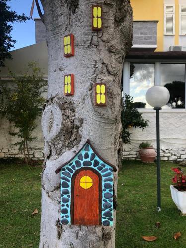 a tree stump with a house painted on it at Hotel Sabatino in Follonica