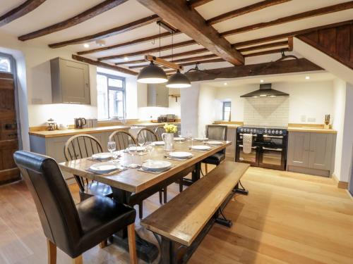 a large kitchen with a wooden table and chairs at Groes Heol in Machynlleth