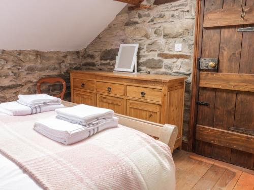 two beds in a room with a stone wall at Groes Heol in Machynlleth