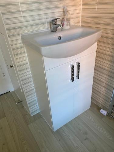 a bathroom with a white sink in a room at Inglewood Guest House in Sandown