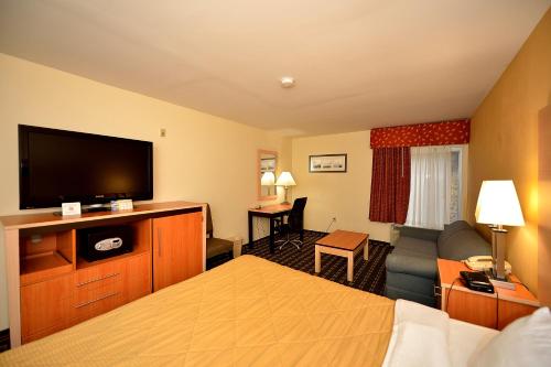a hotel room with a bed and a flat screen tv at Baymont by Wyndham North Dartmouth Fall River in North Dartmouth