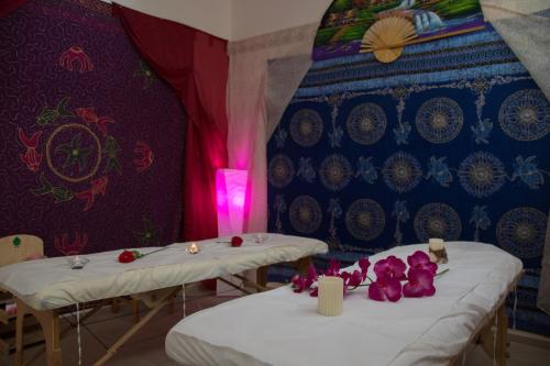 two tables in a room with purple walls and purple flowers at Club del Sole Jesolo Family Resort in Lido di Jesolo