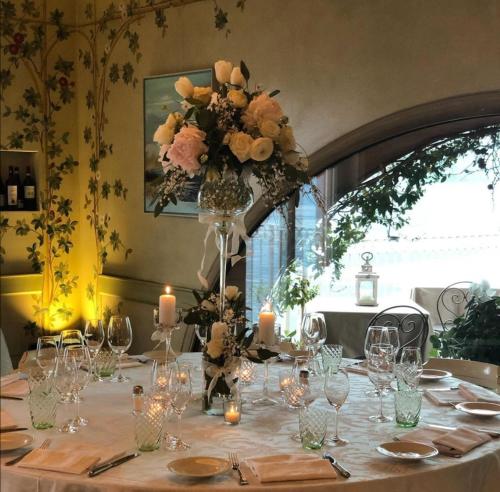 a table with a vase of flowers and candles at La Darsena Boutique Hotel & Restaurant in Tremezzo
