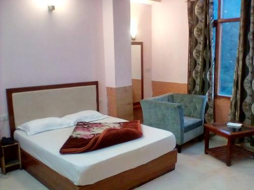 a bedroom with a bed and a chair and a bed and a pillow at Ivy Stays in Shimla