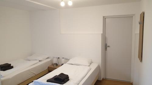 two beds in a room with white walls at Zimmer zur Seeve in Seevetal