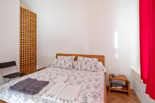 a bedroom with a bed and a red curtain at Ons Nest in Amsterdam