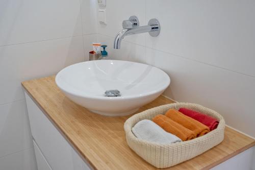a bathroom with a sink and a basket of towels at Ons Nest in Amsterdam