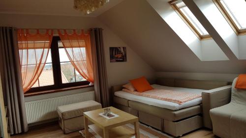 プルシュチ・グダンスキにあるVilla Soleのベッドと窓が備わる小さな屋根裏部屋です。