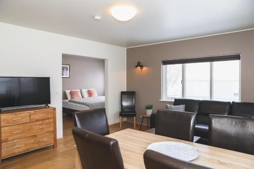 un soggiorno con divano e tavolo con TV di E18 Apartments ad Akureyri