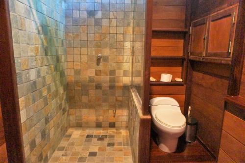 a bathroom with a toilet and a tiled shower at Yellow Houses Bocas DUPLEX in Bocas del Toro