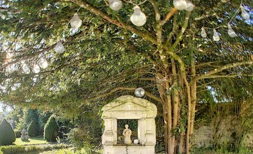 une statue dans une niche sous un arbre dans l'établissement Gîte Jura Lac Emeraude, à Clairvaux-les-Lacs