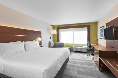 ein Hotelzimmer mit einem großen Bett und einem Schreibtisch in der Unterkunft Holiday Inn Express & Suites - Union Gap - Yakima Area, an IHG Hotel in Union Gap