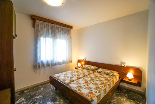 1 dormitorio con cama y ventana en Residence Goletta, en Bibione