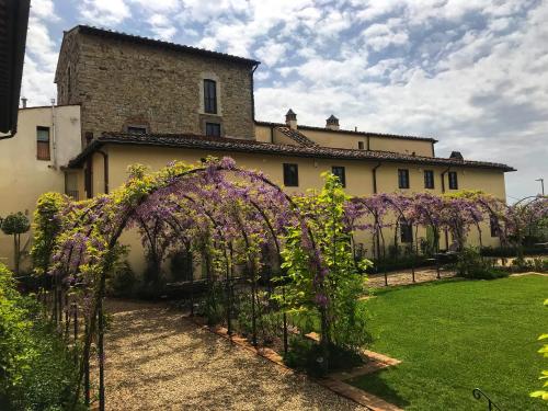 an archway in front of a building with purple flowers at Villa Medicea di Lilliano in Grassina