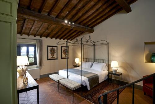 a bedroom with a canopy bed and two chairs at Villa Medicea di Lilliano in Grassina