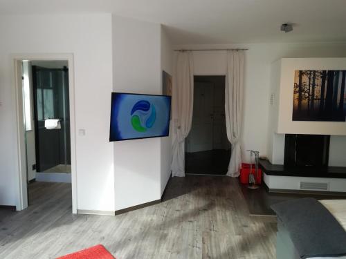 a living room with a flat screen tv on a wall at Waldhotel Forsthaus Remstecken in Koblenz