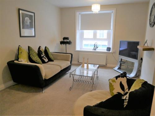 a living room with two couches and a tv at Cosy two bedroom apartment in Bishop Auckland