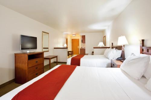 a hotel room with two beds and a flat screen tv at Holiday Inn Express Hotel & Suites Mattoon by IHG in Mattoon